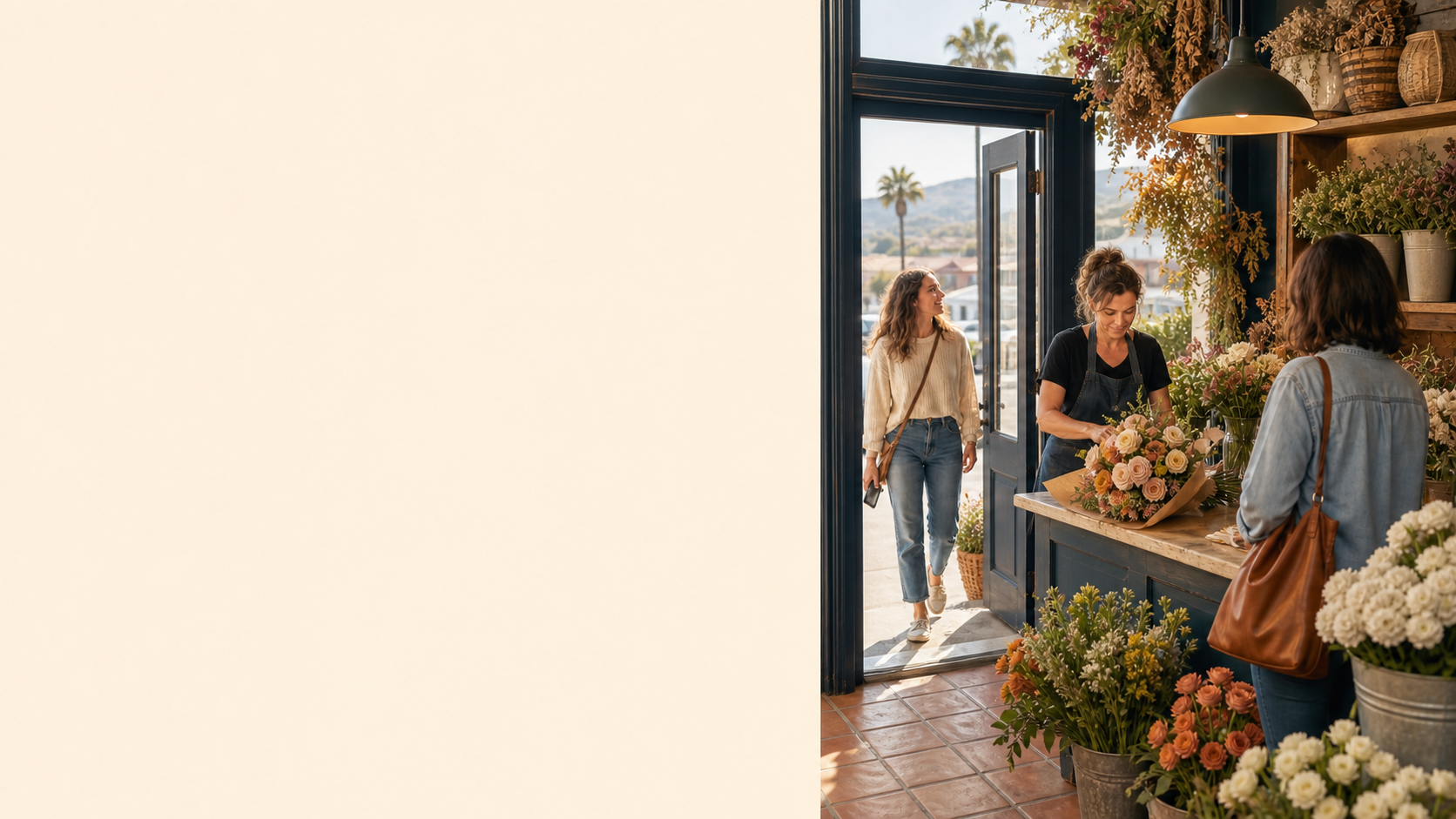 A customer with a phone arrives at a warm local florist while the owner prepares an order